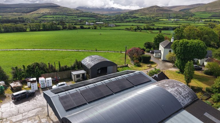 Drone view of the east-west solar array on the cattle shed at the Fitzgerald family farm, Castlegregory, with the farmhouse and Kerry hills behind